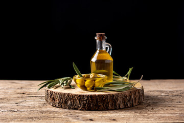 Virgin olive oil bottle and green olives on wooden table
