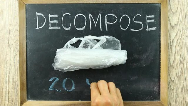 Man drawing  word  Plastic bag   can take up to 20 years to decompose  , in studio  Chiangmai Thailand.