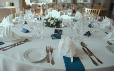 Wedding reception table in the restaurant decorated with white candles and flowers. Close up the set of table in some romantic place
