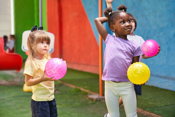Gruppe multikultureller Kinder beim Ball spielen