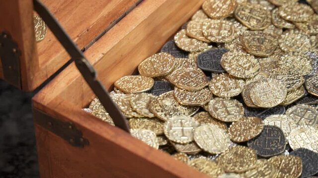 Sideview of Gold Coins hitting a treasure chest