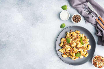 Stewed pasta with minced beef and vegetables, macaroni in Navy style on a plate. grey concrete background. Copy space.
