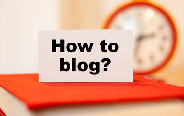 How do I blog? Question on paper against the background of a clock in the blurred background. Blogging concept.