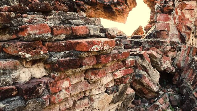 Ruins of old threadbare brick wall. Camera slowly moving upwards.