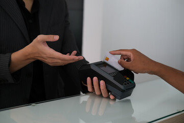 Closed up with reception and customer swipe credit card for payment at the counter, Business and finance concept.