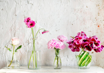 Fototapeta na wymiar A row of vases with pink flowers