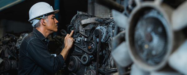 Attractive man working hard and fix Auto mechanic on car engine in mechanics garage. Repair service