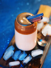 Dalgona coffee, refreshing summer iced coffee . Blue backlight. Cafe menu