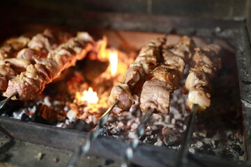 Pork neck cooking on skewers