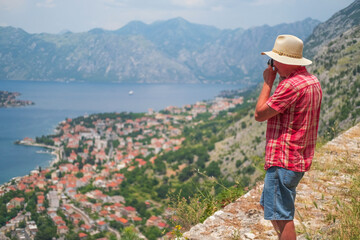 Fototapeta na wymiar Man stands the beautiful nature landscape and makes photos, Montenegro.