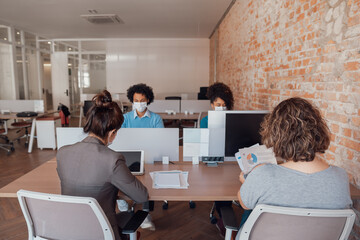 business colleagues working and typing on laptop and tablet in office workspace .