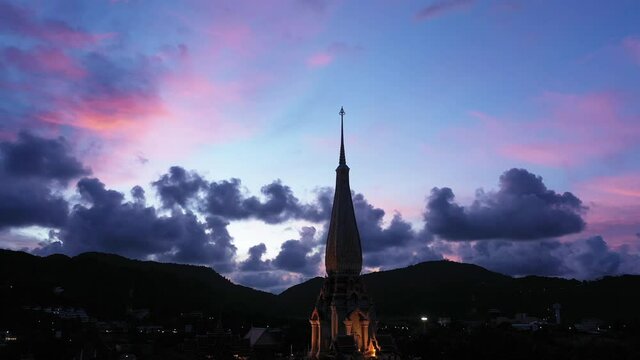 .colorful cloud above pagoda of Chalong pagoda in twilight..beautiful architecture pagoda of Chalong temple in the night..4k colorful cloud scape sky sunset.