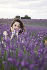 Portrait of a white woman in the lavender fields. Close-up lavender flowers are

