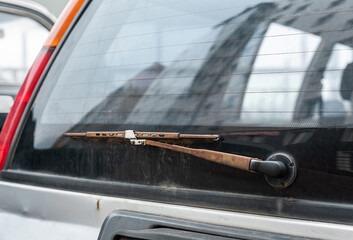 Old rusty car wiper and rear window on an old car