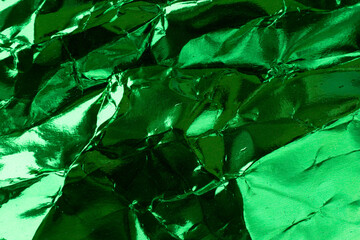 Crumpled green foil paper texture.