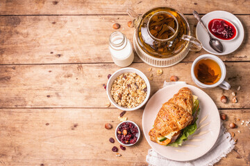 Healthy breakfast concept. Morning good mood with tea, croissant, granola, milk, and jam