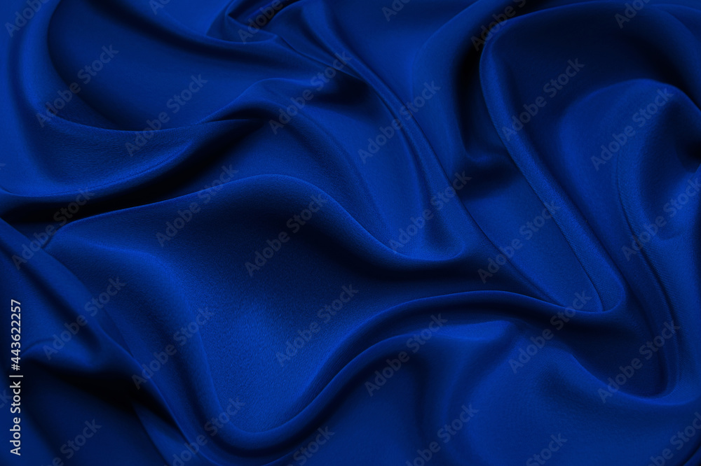 Wall mural close up of ripples in blue silk fabric. satin textile background.