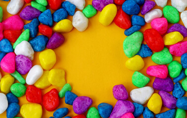 Fototapeta na wymiar colored pebbles on yellow background