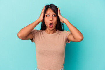 Young latin woman isolated on blue background being shocked, she has remembered important meeting.