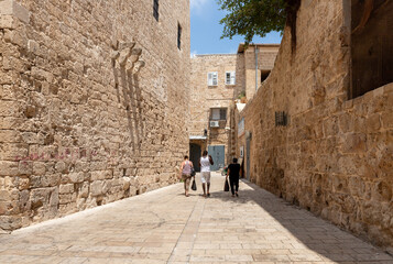 Fototapeta na wymiar Old stone street with old stone houses in the old city of Acre in northern Israel