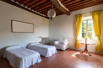 Interior of a bedroom with two single beds. Spartan ambiance and nothing luxurious. There are no people inside.