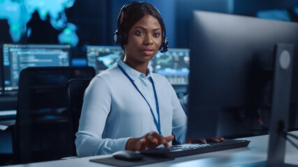 Joyful Beautiful Technical Customer Support Specialist is Talking on a Headset while Working on a...