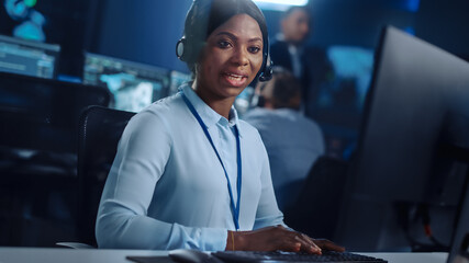 Joyful Beautiful Technical Customer Support Specialist is Talking on a Headset while Working on a...
