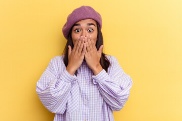 Young mixed race woman isolated on yellow background shocked covering mouth with hands.