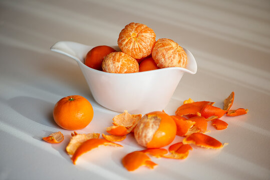 Peeling Tangerines Or Clementines In White Dish, Isolated On White Background