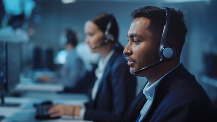 Close Up Portrait of a Joyful Technical Customer Support Specialist Talking on a Headset while...