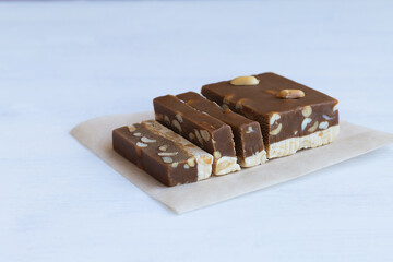 cutting chocolate and milk sherbet with nuts and peanuts on the white table. national traditional sweetness of Turkish and arabic sherbet on the white background. sweet dessert with copy space.