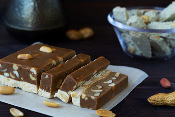 cutting chocolate and milk sherbet with nuts on the black table.dessert and coffee.copy space.national traditional sweetness of Turkish and arabic sherbet and halva sunflower.