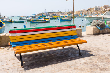 Fototapeta na wymiar Beautiful colorful bench in Marsaxlokk, a traditional fishing village in the country of Malta.