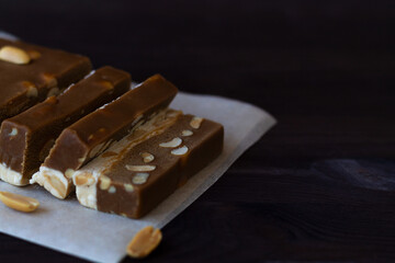 cutting chocolate and milk sherbet with nuts on the black table with copy space.national traditional sweetness of Turkish and arabic sherbet and halva sunflower.