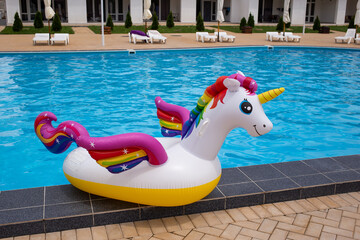 Inflatable unicorn in pool. Pool party, summer holidays, beach vacation. Fantasy swim ring for summer pool trip. Copyplace, place for text © Marharyta
