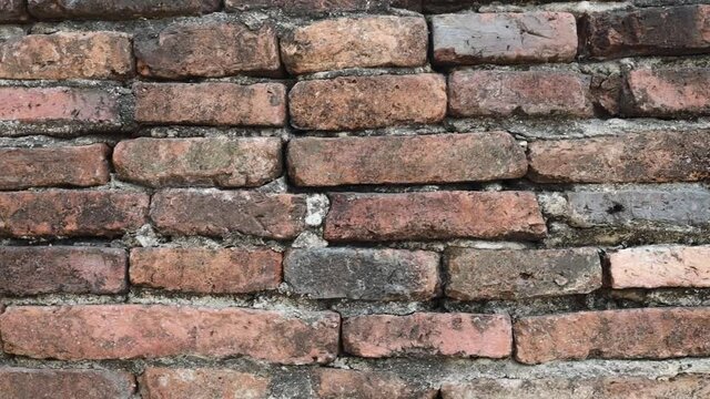 Dingy old threadbare brick wall. Camera close up slowly moving from left to right.