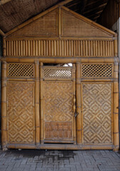 Front view of Javanese traditional house. The wall, windows, door and frame made from yellow bamboo.