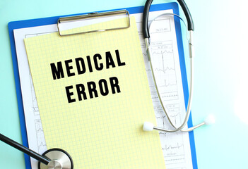 Blue medical clipboard with a sheet of yellow paper with the text MEDICAL ERROR and a stethoscope on a blue background.