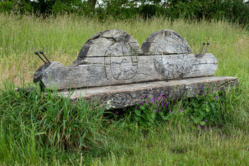 unusual bench carved into the shape of a snail in the English countryside