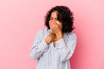 Young curly latin woman isolated on pink background suffers pain in throat due a virus or infection.