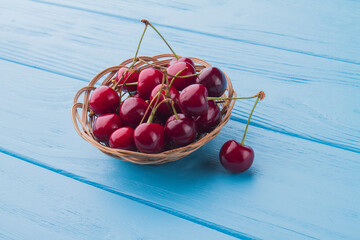 Obraz na płótnie Canvas Pile of fresh ripe red cherries in a wicker bowl.