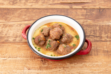 Red enameled pan with a wonderful recipe for meatloaf stewed with vegetables on sauce and mashed potatoes