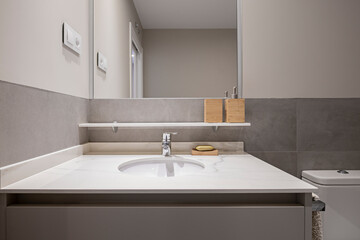 Fototapeta premium Sink with white marble countertop and tiles, paint and gray furniture