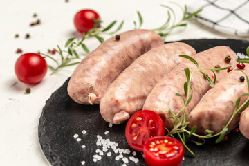 raw sausages with spices and rosemary. Food recipe background. Close up