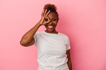 Young african american woman isolated on pink background excited keeping ok gesture on eye.