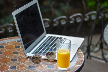 laptop and orange juice for online work in summer
