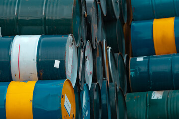 Old chemical barrels stack. Blue, green, and yellow chemical drum. Steel tank of flammable liquid....