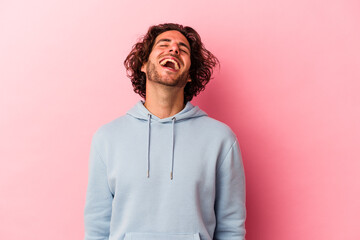 Young caucasian man isolated on pink bakcground relaxed and happy laughing, neck stretched showing teeth.