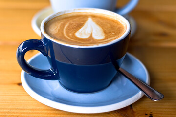 coffee with a heart in the middle in a blue cup