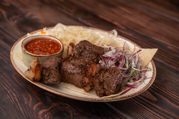 Juicy grilled BBQ meat with salted cabbage, onions and tomato sauce